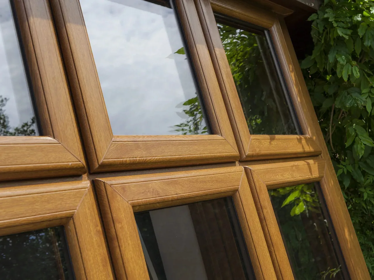Close-up of an oak woodgrain uPVC window frame and glazing bar