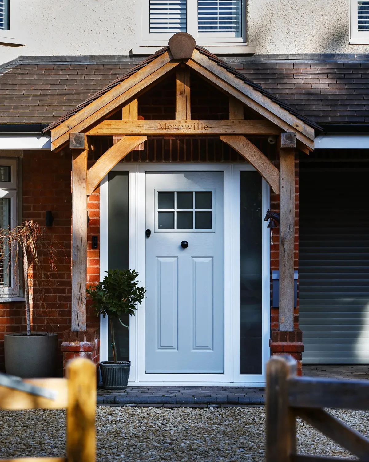House entrance with a grey composite door and white double glazed windows under a porch