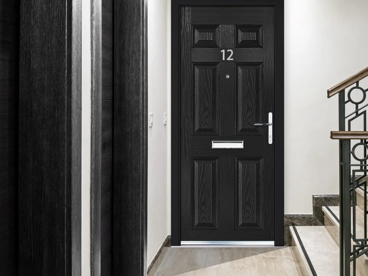 Black flat-entrance fire door numbered 12 beside a communal stairwell with metal balustrade