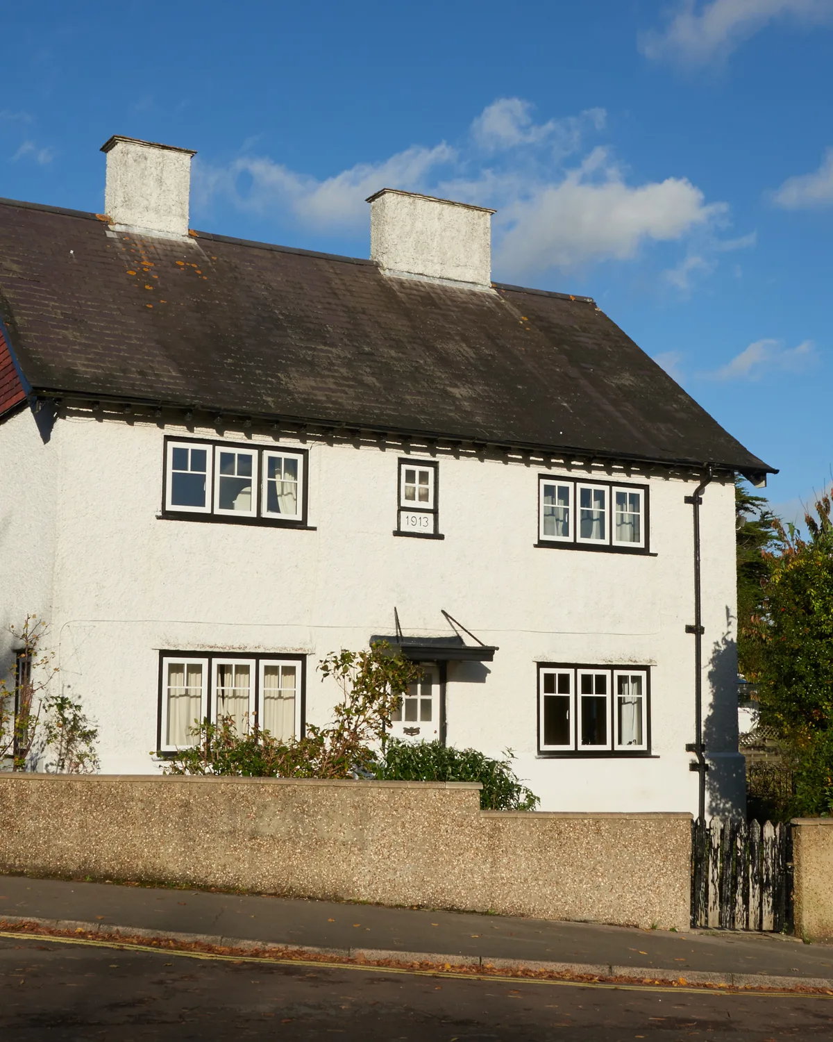 White period house with white flush casement windows and a red-tiled roof