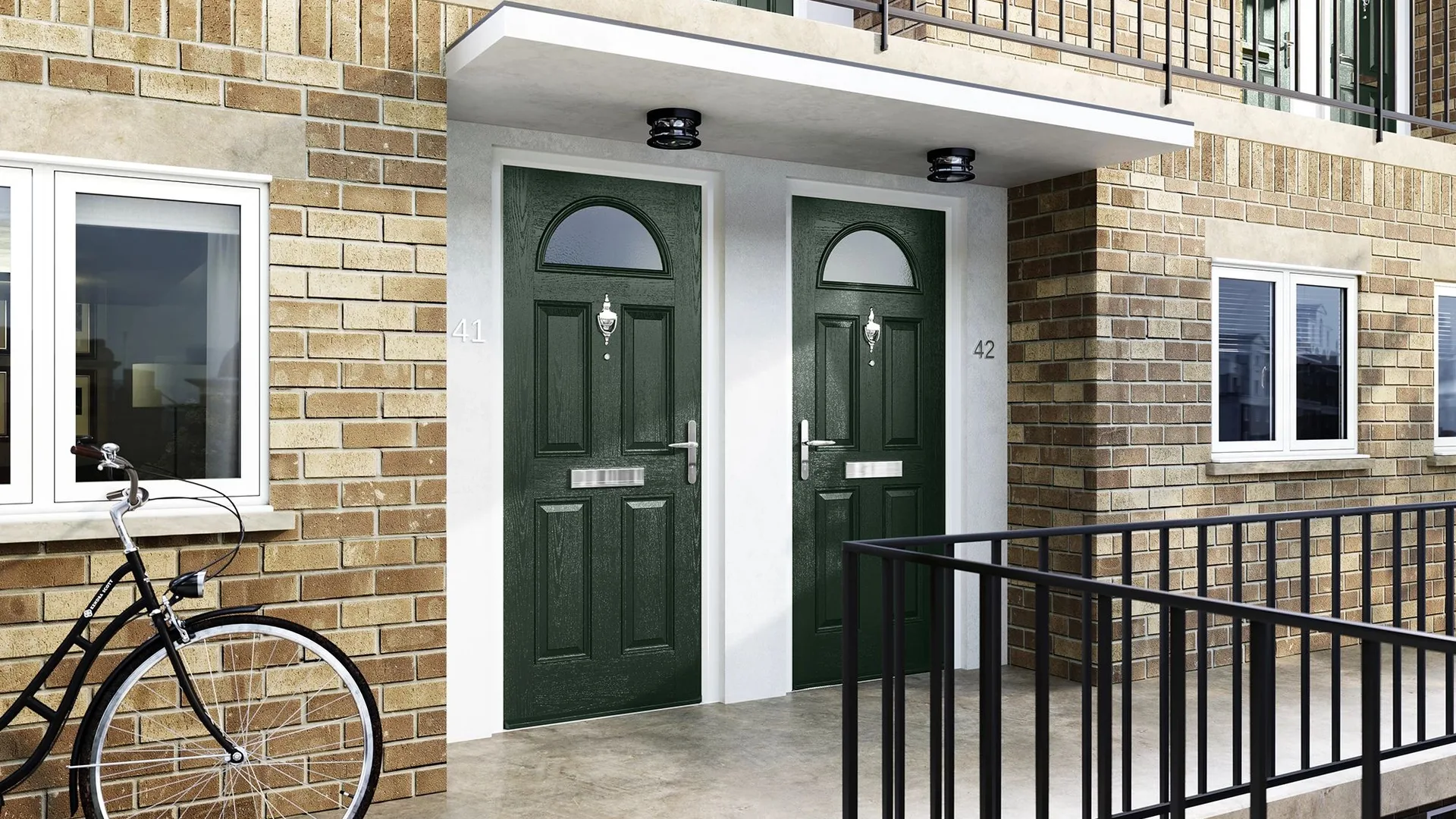 Two dark green composite fire doors with half-moon glazing at the entrance to a brick apartment block