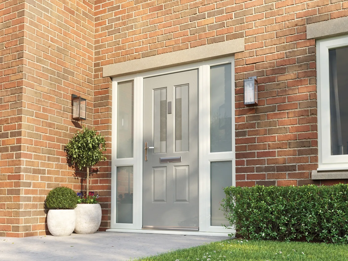 Light grey composite front door with frosted sidelights in a red brick house behind a clipped hedge