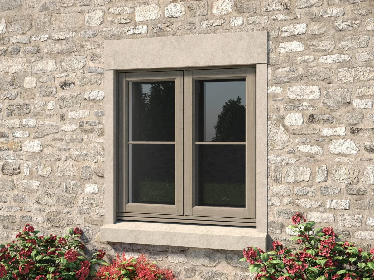 Woodgrain-effect casement window with a stone surround and sill in a rubble stone cottage wall