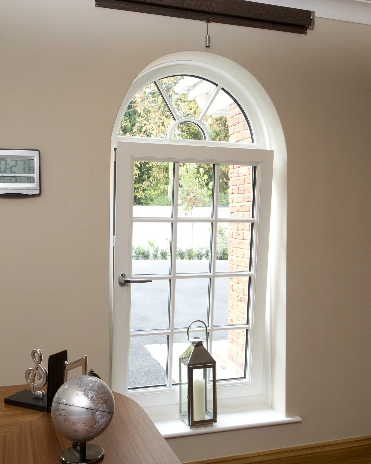 White arched tilt and turn window with Georgian bars, its sash turned open inward in a home office