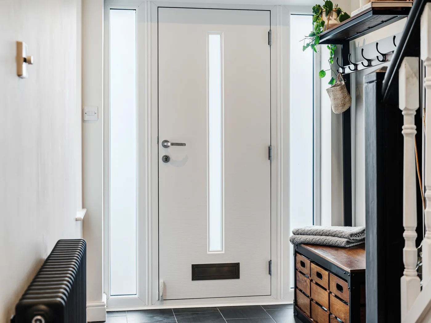 White contemporary composite front door with frosted sidelights seen from inside a hallway