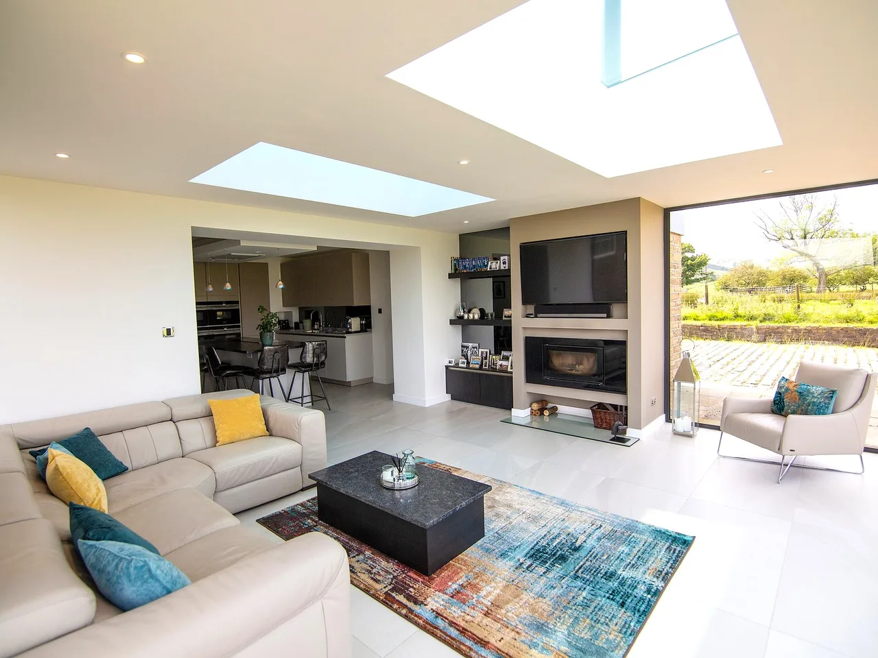 Large roof lantern over an open-plan lounge with corner sofa and glazed doors to the garden