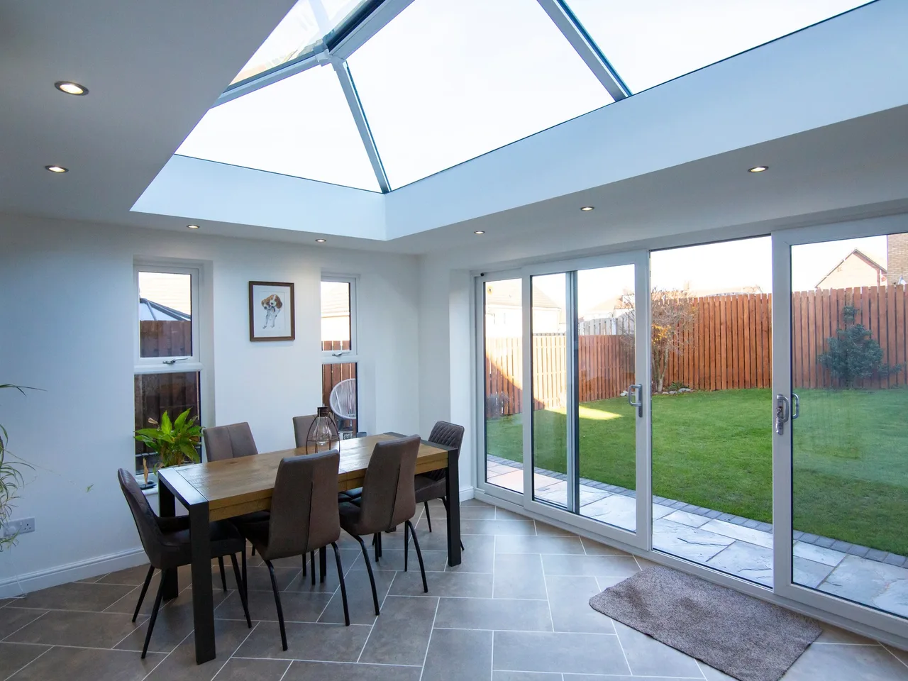 Roof lantern lighting a dining area naturally in daytime with bifold doors closed behind